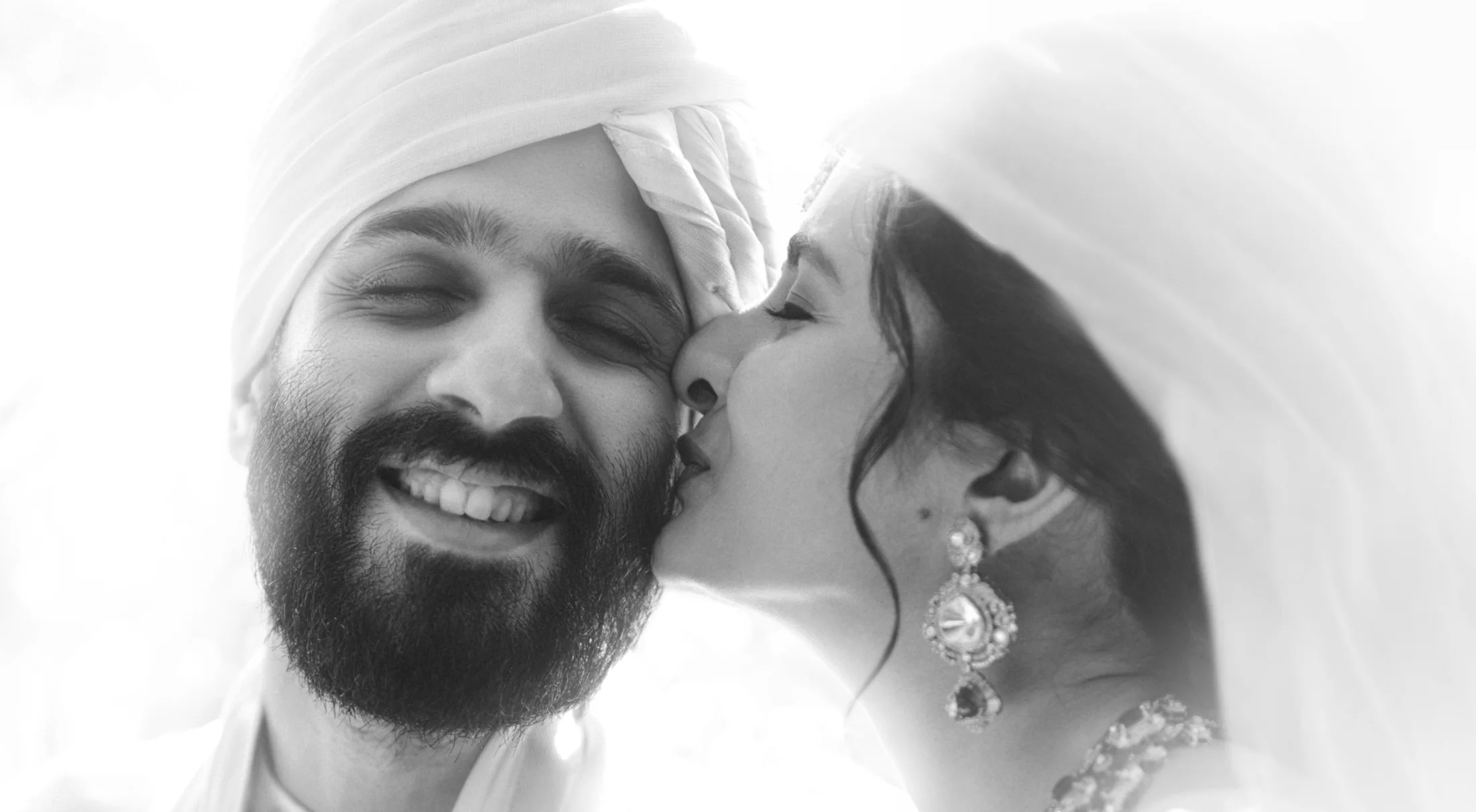 Bride kissing the groom on the cheek on their wedding day